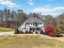 Charming two-story home with manicured lawn, colorful trees, and inviting front porch at 1130 Martins Chapel Rd, Lawrenceville, GA 30045