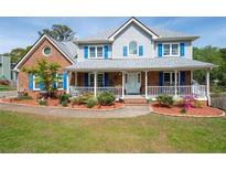 Charming home with a welcoming front porch, manicured lawn and blue shutters at 3174 Country Club Nw Ct, Kennesaw, GA 30144