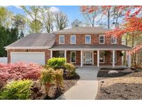Charming brick home with inviting front porch and beautifully landscaped front yard at 3824 Running Fox Dr, Marietta, GA 30062