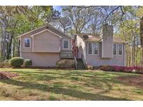 Charming home featuring neutral siding, chimney, and a welcoming entrance with a red door and an American flag at 2806 Peachtree Walk, Duluth, GA 30096