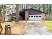 Charming home featuring a stone facade, two-car garage, and a long driveway leading up to the house at 3955 Chimney Ridge Ct, Ellenwood, GA 30294