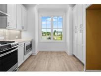 Bright kitchen nook featuring stainless appliances, wood flooring, and an eye-catching window view at 2822 Evanshire Ave # 111, Duluth, GA 30096