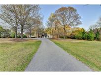 Long driveway leading up to a charming home surrounded by trees on a well-maintained lawn at 1880 Ridgedale Dr, Snellville, GA 30078