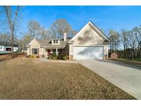 Charming home featuring a well-manicured lawn, two-car garage, and traditional architectural details at 338 Rc Thompson Rd, Dallas, GA 30157