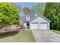 Charming home featuring a brick and siding exterior with an attached two-car garage and well-maintained front yard at 1545 Smoke Hill Dr, Hoschton, GA 30548