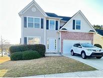 Charming two-story home with a well-manicured lawn and a white SUV parked in the driveway at 771 Franklin Mill Trce, Loganville, GA 30052