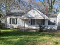 Charming single-story home with a cozy front porch and classic architectural details and mature trees in the background at 1253 Gus Thornhill Jr Dr, Atlanta, GA 30344