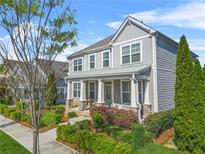 Charming two-story home featuring a welcoming front porch and beautifully landscaped front yard with mature trees at 9893 Colchester St, Douglasville, GA 30135