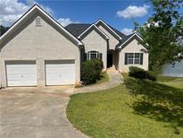 Charming stucco home featuring an attached two-car garage and lakeside views at 203 Sea Marsh Ct, Fayetteville, GA 30215
