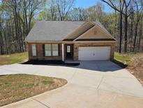 Charming brick home featuring an attached garage and a long driveway for ample parking at 333 Darlington Dr, Ellenwood, GA 30294