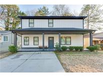 Charming two-story home featuring a welcoming front porch, black framed windows, and a well-maintained lawn at 1506 Avon Sw Ave, Atlanta, GA 30311