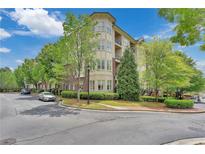 Beautiful condominium building with manicured landscaping and a circular driveway entrance at 3635 E Paces Ne Cir # 1308, Atlanta, GA 30326