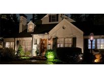 Charming white brick home with inviting front yard landscape and warm exterior lighting at night at 4000 N Stratford Ne Rd, Atlanta, GA 30342