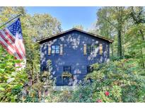 Charming blue home with an American flag, surrounded by lush greenery at 8530 Hightower Trl, Snellville, GA 30039