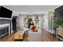 Bright living room featuring a fireplace, large windows, and stylish décor at 303 Gettysburg Pl, Atlanta, GA 30350