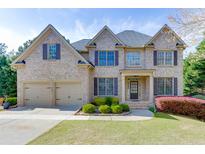 Traditional two-story brick home with a two-car garage, landscaped front yard, and inviting entrance at 4880 Stone Moss Path, Hoschton, GA 30548