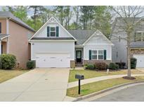 Charming single-Gathering home with a two-car garage, well-maintained lawn, and attractive landscaping at 973 Duncan Ter, Holly Springs, GA 30115