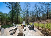 Backyard patio with stamped concrete, fire pit, and seating, surrounded by mature trees and landscaping at 139 Stargaze Rdg, Canton, GA 30114