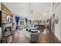 Open-concept living room featuring vaulted ceilings, a modern fireplace, and abundant natural light at 139 Stargaze Rdg, Canton, GA 30114