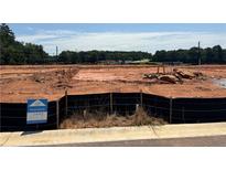 View of available lot with visible signage and cleared land for new construction in a wooded area at 6347 Towhee Way, Morrow, GA 30260