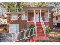 Charming brick home featuring a cozy front porch with red stairs and white railing at 165 Holly Nw Rd, Atlanta, GA 30314