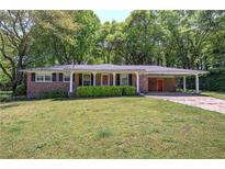 Charming single-story brick home featuring a covered carport and a well-maintained front yard at 4361 Stanley Dr, Powder Springs, GA 30127