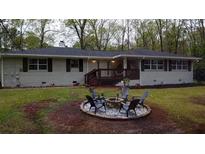 Charming home featuring a brick fire pit and freshly painted exterior and dark trim at 1155 Christian Se Cir, Conyers, GA 30013