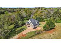 Stunning two-story home featuring a well-manicured lawn, neutral paint, an attached two-car garage, and mature trees at 240 Indian Creek Rd, Locust Grove, GA 30248