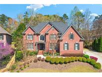 Stunning two-story brick home with manicured landscaping and a charming front entrance at 785 Westwind Ln, Alpharetta, GA 30005