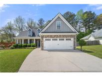 Charming two-story home with stone accents, a well-manicured lawn, and an attached two-car garage at 2232 Ann Ln, Lithia Springs, GA 30122