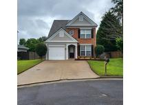 Charming two-story home with brick and siding exterior and well-maintained front yard with driveway and landscaping at 1503 Korona Ct, Woodstock, GA 30188