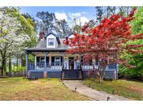 Beautiful two-story home with front porch, colorful tree, and landscaped front yard at 2425 Shiloh Sw Dr, Marietta, GA 30064
