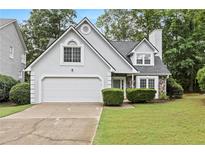 Charming home featuring stone accents, a two-car garage, and a well-maintained lawn at 995 Litchfield Pl, Roswell, GA 30076