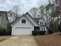 Charming home featuring a two-car garage, stone accents, and a well-maintained front yard at 995 Litchfield Pl, Roswell, GA 30076