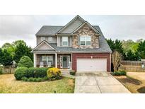 Beautiful two-story home with a stone and brick facade and a well-manicured front yard at 6675 Flagstone Ct, Cumming, GA 30028