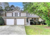 Charming two-story home with a two-car garage and a well-manicured front yard at 5880 April Dr, Sugar Hill, GA 30518