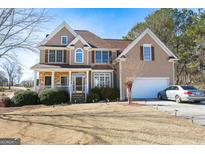 Charming two-story home with a stone-accented porch, manicured lawn and an attached two-car garage at 190 Country Club Dr, Hiram, GA 30141