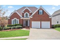Charming red brick home with a well-maintained lawn, landscaping, and a two-car garage at 4093 Tritt Homestead Dr, Marietta, GA 30062