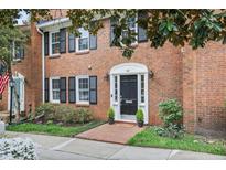 Charming brick townhouse with black shutters, black door, and landscaped front yard. Red brick pathway to door at 4620 Wieuca Ne Rd # 24, Atlanta, GA 30342