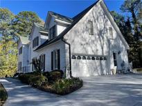 Charming white brick home with two-car garage and mature landscaping at 4748 Arcado Sw Rd, Lilburn, GA 30047