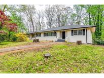 Charming single-story home with painted brick, black accents, and a well-manicured lawn at 1714 Highland Pl, Decatur, GA 30035