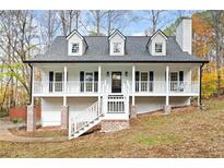 Charming white two-story home with a welcoming front porch and a well-manicured lawn at 501 Mcdaniel Nw Rd, Marietta, GA 30064