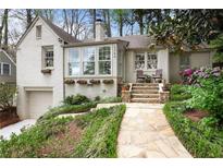 Charming painted brick home featuring a stone walkway, multiple windows and a well landscaped yard at 1794 Charline Ne Ave, Atlanta, GA 30306