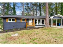 Charming home featuring a brick facade, orange shutters and a convenient carport at 2318 Plantation Dr, Atlanta, GA 30344
