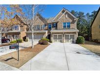 Beautiful brick townhome with a two-car garage and well-maintained landscaping and a long driveway at 6160 Shiloh Woods Dr, Cumming, GA 30040