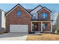 Charming brick home featuring an attached garage and a welcoming front porch at 7902 West Shore Cir, Riverdale, GA 30296