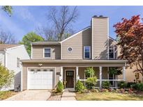 Charming two-story home featuring a covered front porch and attached garage with nice landscaping and mature trees at 125 Hibernia Ave, Decatur, GA 30030
