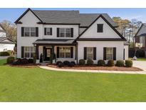 Beautiful two-story home with a well-manicured lawn and a classic white brick facade at 240 Brookwood Estates Dr, Alpharetta, GA 30005