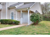 Inviting home exterior featuring a well-manicured lawn and a charming, covered front entrance at 6502 Wellington Chase Ct, Lithonia, GA 30058