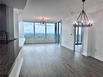 Bright living room featuring floor-to-ceiling windows with a stunning city view and modern light fixtures at 3338 Peachtree Ne Rd # 2701, Atlanta, GA 30326